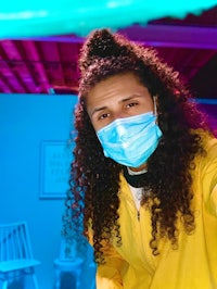 a woman wearing a surgical mask in a blue room