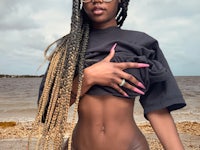 a black woman in a bikini posing on the beach